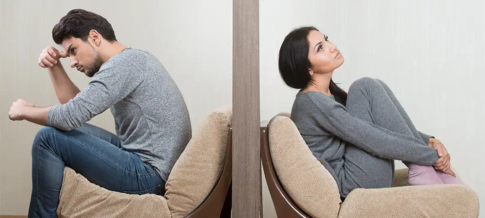 conflict between man and woman sitting on either side of a wall