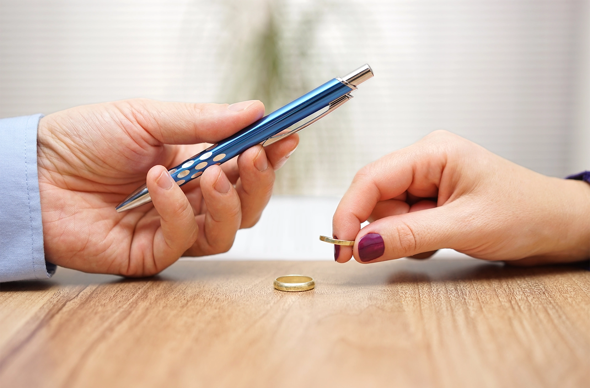 Husband is giving pen to sign divorce papers his former wife after he take off the ring form finger